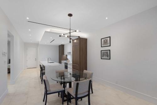 a dining room and kitchen with a table and chairs at Modern Condo at One Cable Beach with Balcony in Nassau