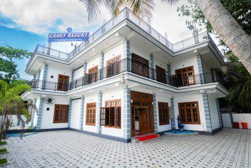 a large white building with a balcony at Ramiy Resort Batticaloa in Batticaloa