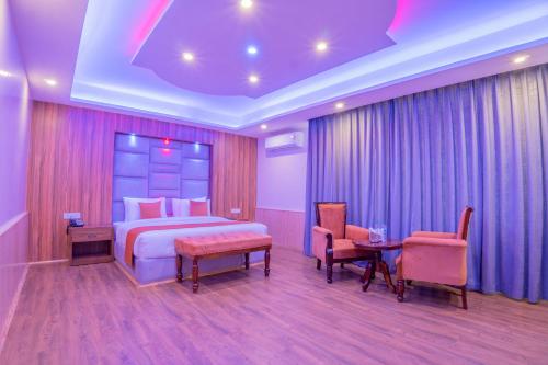 a bedroom with a bed and two chairs and a table at Hill River Resort By West Western in Manāli