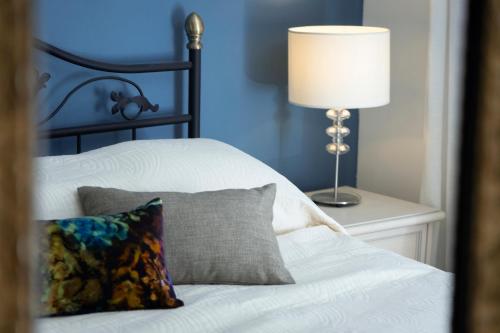 a bed with a pillow and a lamp on a table at Villa Nauta in Lovište