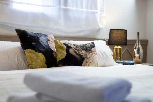 a bed with white sheets and pillows with a window at Villa Nauta in Lovište