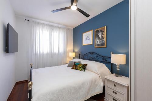a blue bedroom with a bed and a ceiling fan at Villa Nauta in Lovište