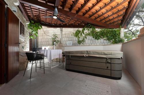 an outdoor kitchen with a table and chairs under a roof at Villa Nauta in Lovište
