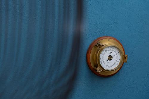 a gold clock on the side of a blue wall at Villa Nauta in Lovište