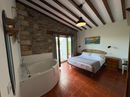 a bedroom with a bed and a bath tub at Posada Punta Liñera in San Vicente de la Barquera