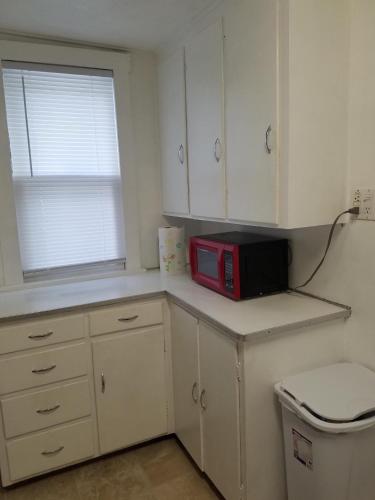 a kitchen with a red microwave on a counter at Roomy 1 Bdrm House-Hi-Speed Internet-Great for Cple-Sml Family-Easy to Get About in Whitehall