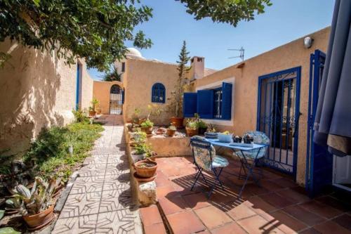 eine Terrasse mit Tisch und Stühlen vor einem Haus in der Unterkunft Cortijo con encanto in Mojácar