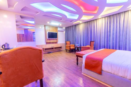 a hotel room with a bed and a television at Hill River Resort By West Western in Manāli