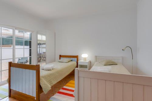 two beds in a bedroom with a balcony at Spacious Villa - Walk to Beach & City Center in Lagos