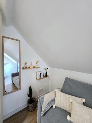un salon avec un canapé et un miroir dans l'établissement Le Petit Pontoise, à Pontoise