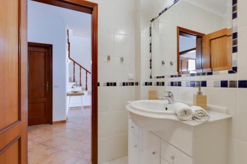 a white bathroom with a sink and a mirror at Spacious Villa - Walk to Beach & City Center in Lagos