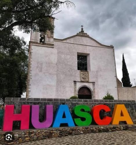 a sign in front of a church with a building at Casa Boutique La Loma in Huasca de Ocampo