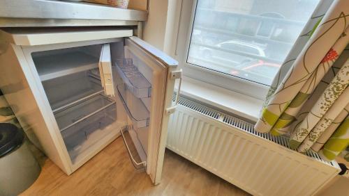 a refrigerator with its door open next to a window at Aparthotel B & L in Bremen