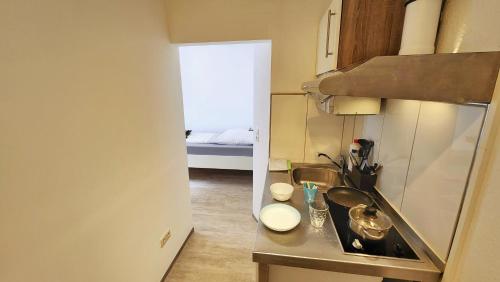a small kitchen with a sink and a bed at Aparthotel B & L in Bremen