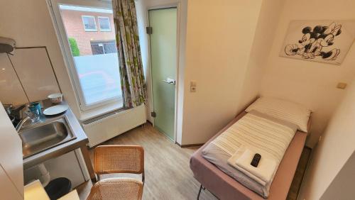 a small room with a small bed and a sink at Aparthotel B & L in Bremen