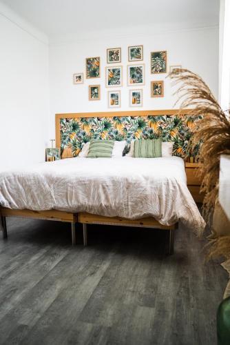 une chambre avec un grand lit avec une tête de lit en bois dans l'établissement La Belle Escale d'Epinay aux portes de Paris, à Épinay-sur-Seine