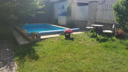 a swimming pool in a yard with a table and a table sidx sidx at Rodinný dům v Praze s bazénem in Prague