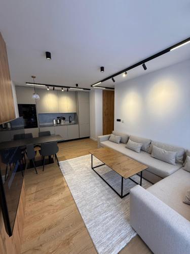 プリシュティナにあるCherry Apartmentのソファとテーブルのあるリビングルーム