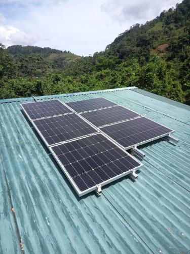 a group of solar panels on top of a roof at Preciosa Cabaña de Montaña in Turrialba