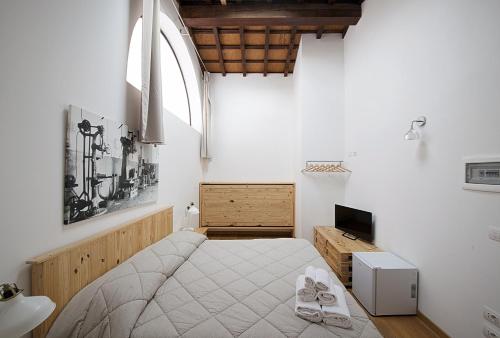 a bedroom with a bed and a large window at Le Camere Pietrasantine - Garage Bonci in Pietrasanta