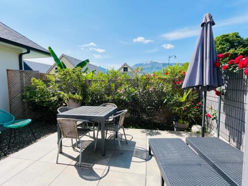 - une table, des chaises et un parasol sur la terrasse dans l'établissement La maison de Lilette proche Argelès Gazost, à Ayzac-Ost