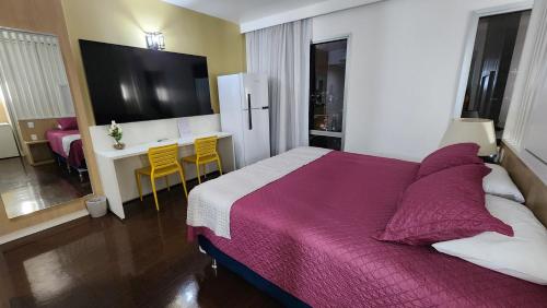 1 dormitorio con 1 cama grande y escritorio con sillas en Joia Rara no Hotel Mercure, en Manaus
