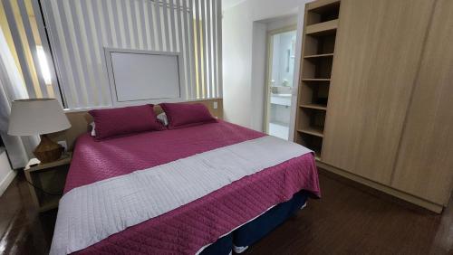 1 dormitorio con 1 cama grande con sábanas moradas y blancas en Joia Rara no Hotel Mercure, en Manaus