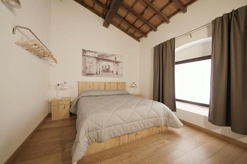 a bedroom with a bed and a large window at Le Camere Pietrasantine - Garage Bonci in Pietrasanta