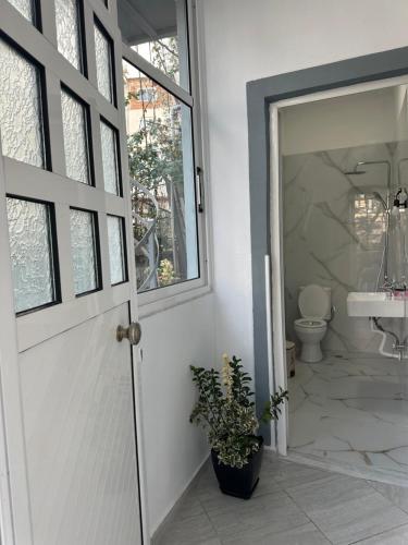 a bathroom with a door and a sink and a toilet at Chris apartament 2 in Polisi i Vogël