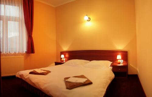 1 dormitorio con 1 cama con 2 toallas en Dwór Jur-Gast, en Wisła