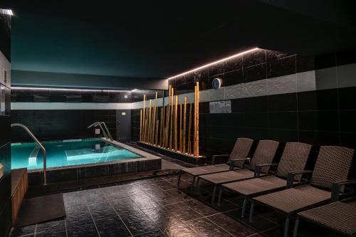 a room with a pool with chairs and a spa at Douro Marina Hotel & SPA in Resende