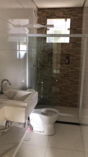a bathroom with a toilet and a sink and a shower at Recanto sao miguel in Ilhéus