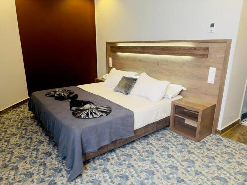 a bedroom with a large bed with a wooden headboard at Blue sky hotel in Oran