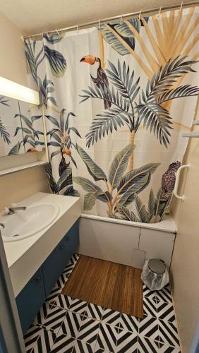 une salle de bain avec un lavabo et un rideau de douche dans l'établissement Studio cabine au couchant, à La Grande Motte