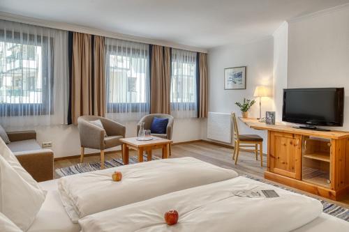 a hotel room with two beds and a flat screen tv at Hotel Alte Post in Grossarl