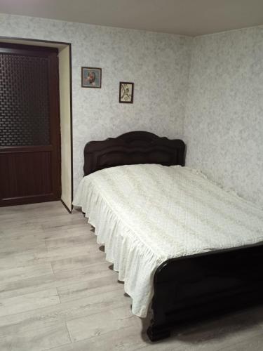 a bedroom with a large bed with a white blanket at Guesthouse - Happy house in Kutaisi in Kutaisi