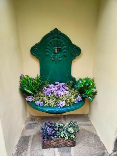 a green planter with flowers on the side of a wall at Bed and Breakfast Tvrz in Velká Bukovina
