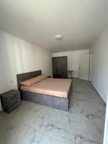 a bedroom with a bed in a room with marble floors at 9apartaments Shengjin in Shëngjin