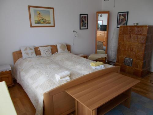 1 dormitorio con cama grande y mesa de madera en Liliom Apartments Balatonfüred, en Balatonfüred