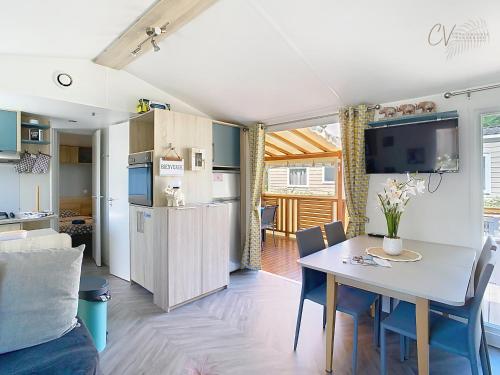 une cuisine et un salon avec une table et des chaises dans l'établissement Mobil-home JA 68 à Vias - La Carabasse - Camping Siblu avec Piscine, à Vias