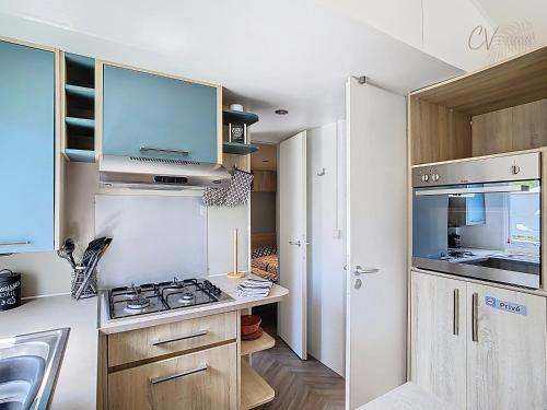 Il comprend une petite cuisine équipée d'une cuisinière et d'un évier. dans l'établissement Mobil-home JA 68 à Vias - La Carabasse - Camping Siblu avec Piscine, à Vias