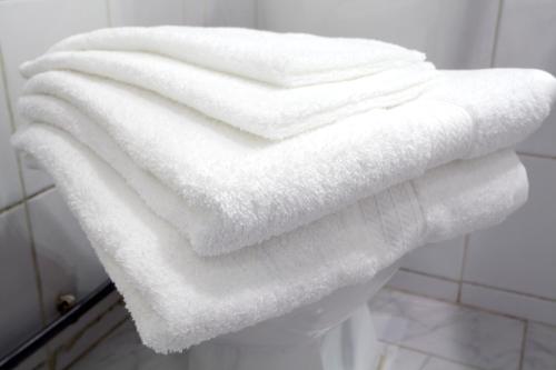 uma pilha de toalhas brancas sentadas num banco na casa de banho em Tower Bridge Apartment em Londres