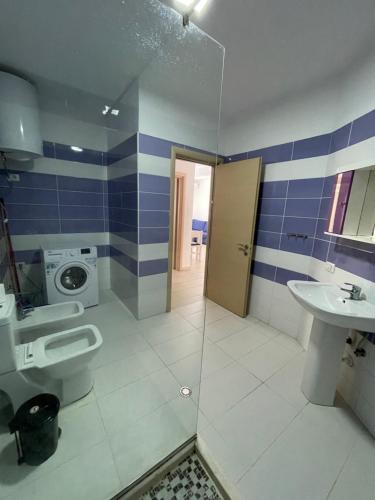 a bathroom with a toilet and a sink and a shower at Cappuccino Apartment Shengjin in Shëngjin