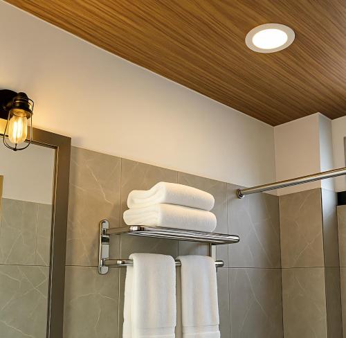a bathroom with white towels on a towel rack at Hotel Casa Acueducto - Lujo Cultural in Oaxaca City