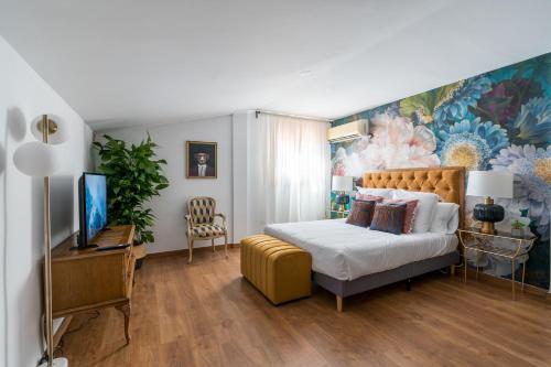 una camera da letto con un letto e un quadro sul muro di Constanza, la vecina de Cervantes ad Alcalá de Henares