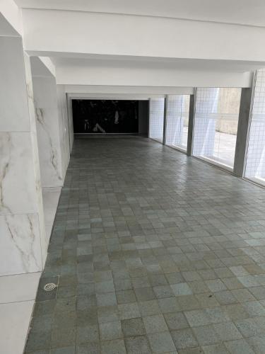 a large empty room with a tile floor and windows at Extraordinary Seafront Apartment in Recife