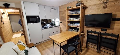 - une petite cuisine avec une table et une télévision dans la chambre dans l'établissement Cocon cozy, vue magique, à Demi-Quartier