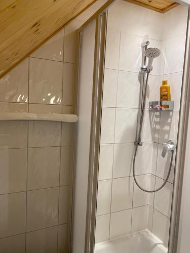 una doccia con soffione in un bagno di Ferienhaus Leuchtturmblick Hafendorf Rheinsberg a Rheinsberg