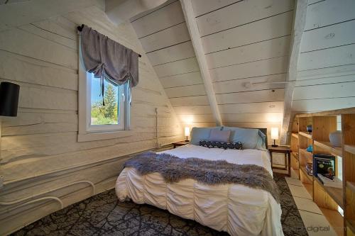 a bedroom with a bed in a room with a window at New Everything! Gorgeous Log Cabin in Downtown Joseph in Joseph