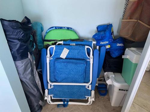 a small room with a blue suitcase and bags at Hutchinson Island BeachFront Heated Pool Balcony Top Floor Amazing View in Jensen Beach